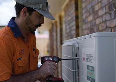 Technician installing a split system air conditioner in Brisbane