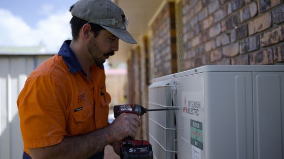 Technician installing a split system air conditioner in Brisbane